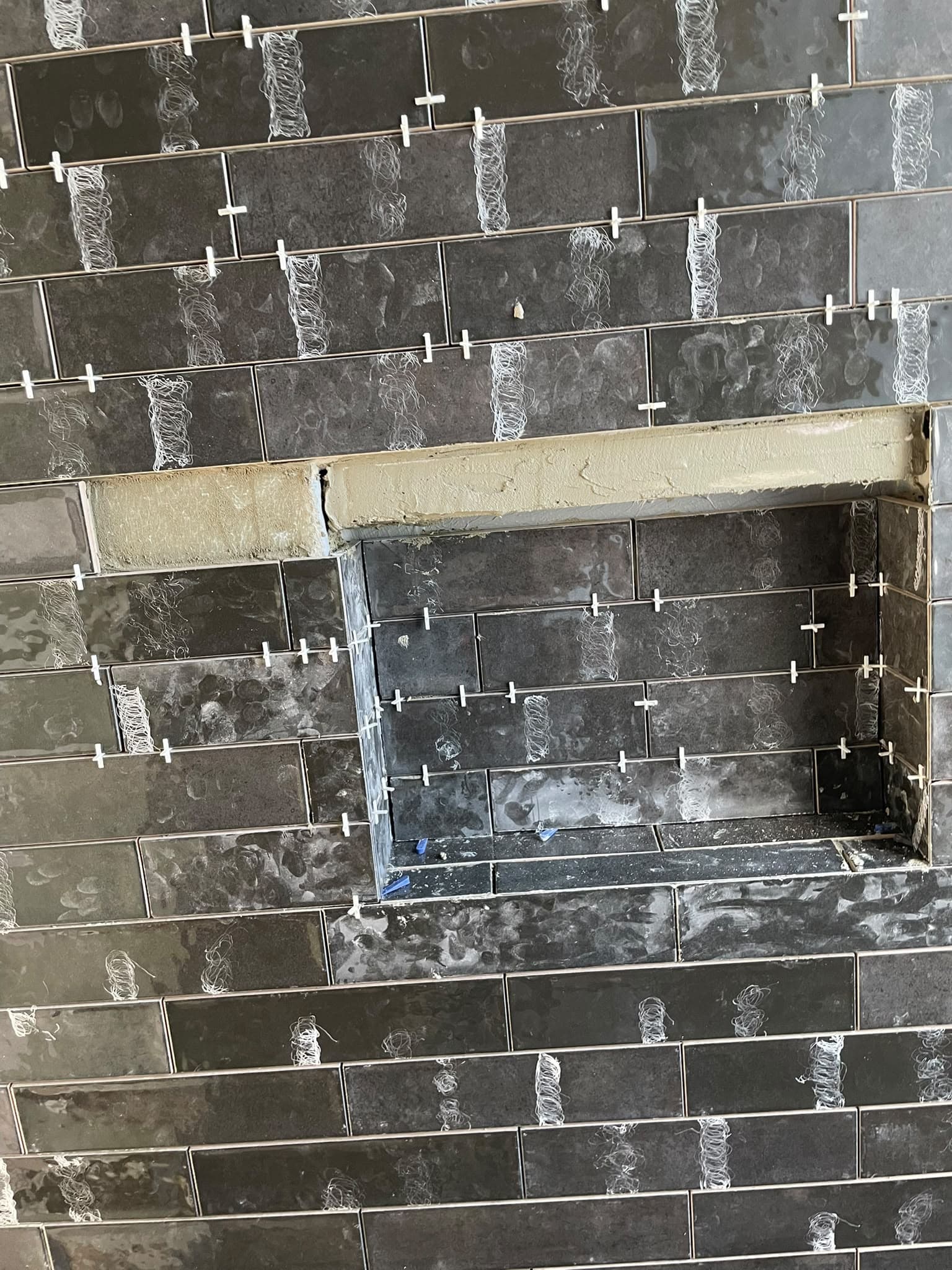 Dunkel geflieste Wand mit einer Nische