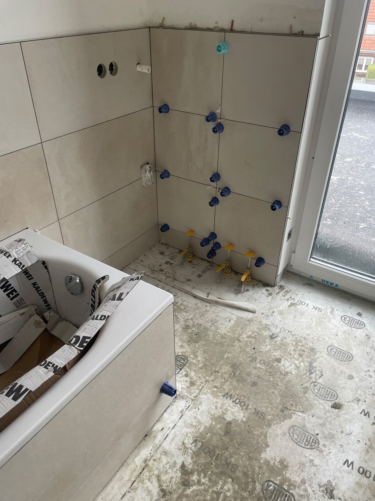 Geflieste Badezimmerwände mit noch unfertigem Boden