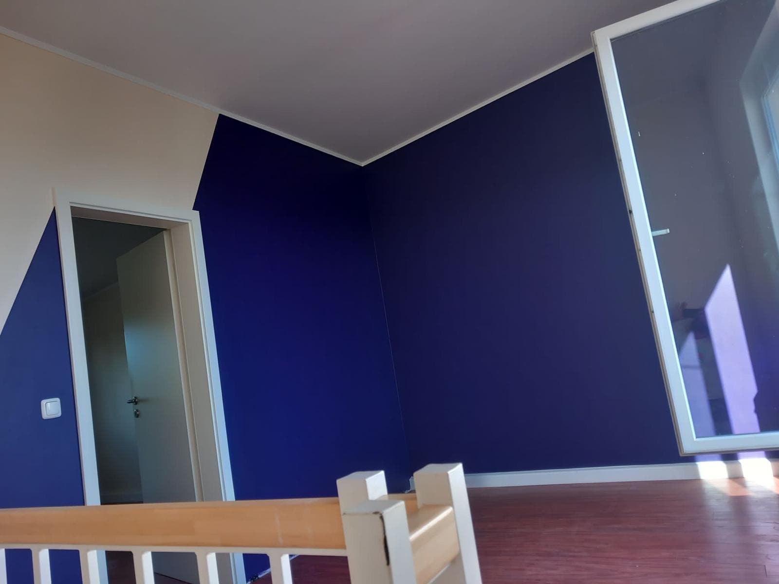 Raum mit dunkelblauer Wand und Holzfußboden